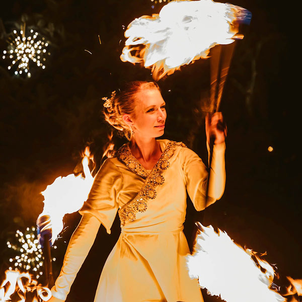 Kvinna dansar med eldfacklor under Vinter på Norrviken.